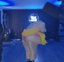 a person in a pink and yellow outfit is standing in front of a microphone in a room