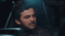a man in a plaid shirt is making a funny face