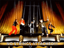 a group of people dancing on a stage with the words no strings attached
