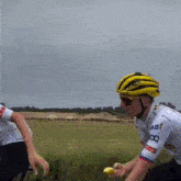 a man wearing a yellow helmet and sunglasses rides a bike