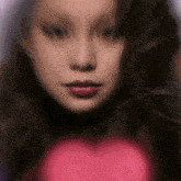 a blurred image of a woman 's face with a pink heart in the background
