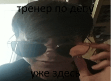 a man wearing sunglasses talks on a cell phone in a foreign language