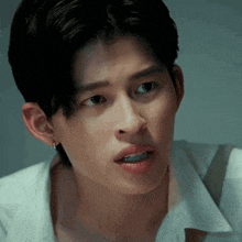a close up of a person 's face with a white shirt