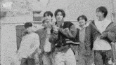 a group of young men are standing in front of a chain link fence with the word who on the bottom right