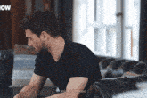 a man in a black shirt is sitting on a couch with the words minimalmoons written on the bottom