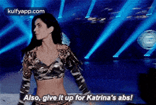 a woman is dancing on a stage and saying `` also , give it up for katrina 's abs ! ``