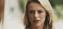 a close up of a woman 's face with a serious expression .