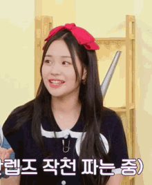 a girl wearing a red headband with korean writing on it smiles