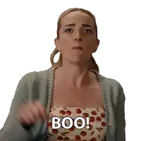 a woman wearing a cardigan and a cherry print dress says boo
