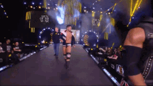 a wrestler is walking down a runway with a sign that says men of the year