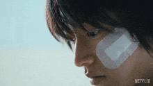 a close up of a person 's face with a bandage on it that says netflix on it