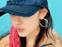 a woman wearing a hat and hoop earrings