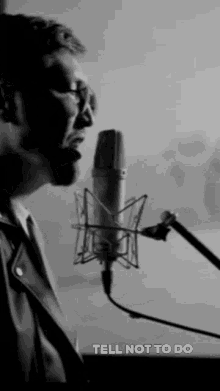 a black and white photo of a man singing into a microphone with the caption tell not to do