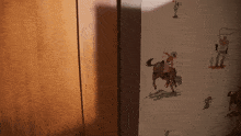 a cowboy riding a horse on a wall with other cowboys