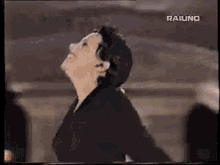 a woman in a black jacket is dancing in front of a crowd .