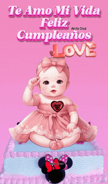 a baby in a pink dress is sitting on a cake with the words te amo mi vida feliz cumpleanos love