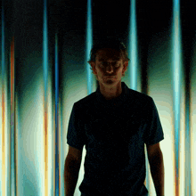 a man in a nike shirt is standing in front of a wall of lights