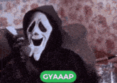 a person wearing a ghostface mask is sitting on a couch with a cat .