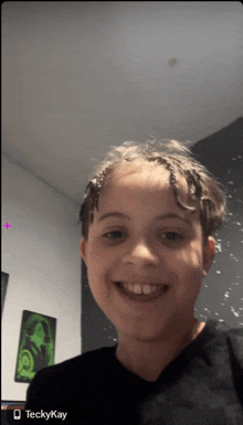 a young boy is smiling with the name teckykay on the bottom of the screen