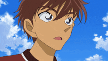 a close up of a boy 's face against a blue sky