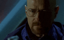 a man with a beard wearing glasses and a blue shirt