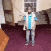 a young boy is standing in a room holding a rope .