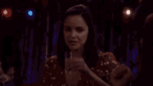 a woman is drinking a shot of tequila in a dark room .