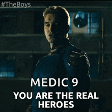 a man in a superhero costume with the words medic 9 you are the real heroes below him