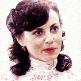 a close up of a woman 's face wearing a white turtleneck