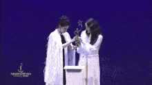 two women holding a trophy that says nineentertainment awards on it