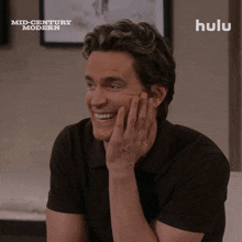 a man in a black shirt is smiling in front of a sign that says mid century modern