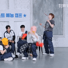 a group of young men are playing a game in front of a sign that says temple