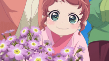a little girl in a pink kimono holds a bouquet of purple flowers