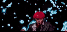 a man with red hair is wearing a black jacket and a leopard print shirt .