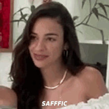 a woman with long dark hair is smiling and the word safffic is on the bottom right