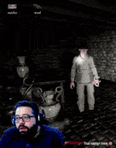 a man wearing headphones is playing a video game in a dark cave