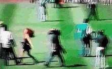 a blurry picture of people walking on a green field with the word gif on the bottom right