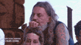 a man with long hair and a beard has a tattoo on his arm that says la palapa esterna