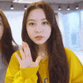 a woman wearing a yellow sweatshirt with the letter c on the front
