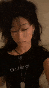 a close up of a woman 's face with a necklace that says " bitch " on it