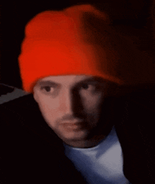 a close up of a man wearing an orange hat .