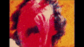 a close up of a painting of a person 's face with red paint on it .