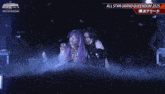 two women are standing next to each other with the words all star grand queendom 2025 on the bottom