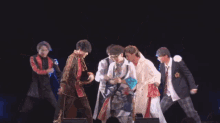 a group of young men are dancing on a stage
