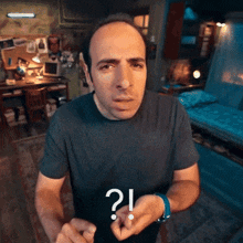 a man in a black shirt has a question mark on his finger