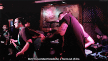 a man singing into a microphone with the words but i 'm a constant headache a tooth out of line below