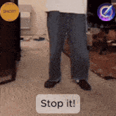 a person standing in a room with a sign that says " stop it "