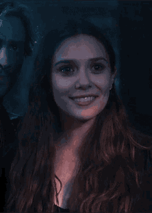 a close up of a woman 's face with a man behind her