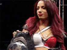 a woman with red hair is holding a trophy .