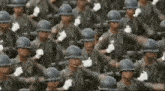 a large group of soldiers are marching in a parade and saluting .